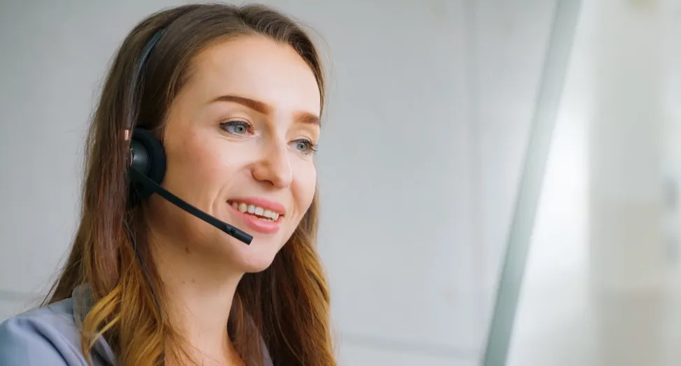 Customer service agent with a headset smiling during a call