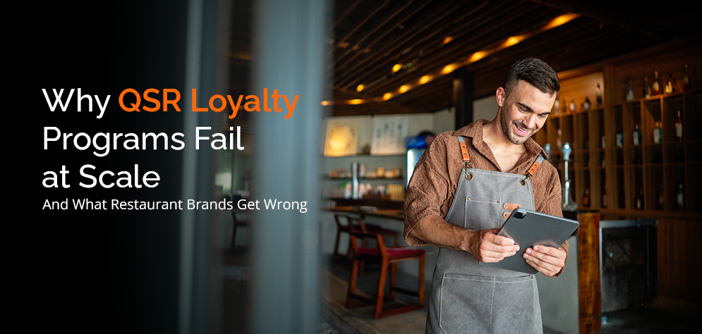 Restaurant manager reviewing loyalty program data on tablet highlighting why QSR customer retention strategies fail at scale